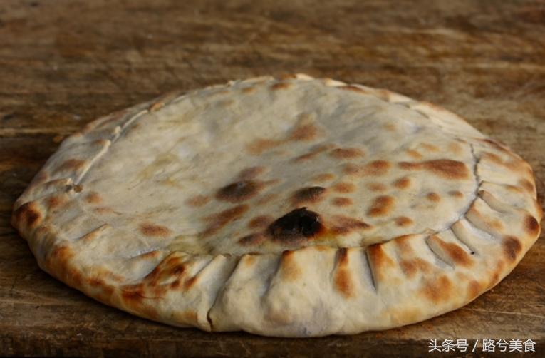 把大饼贴在火炉里面烤熟,把饼放在烤炉里面烤